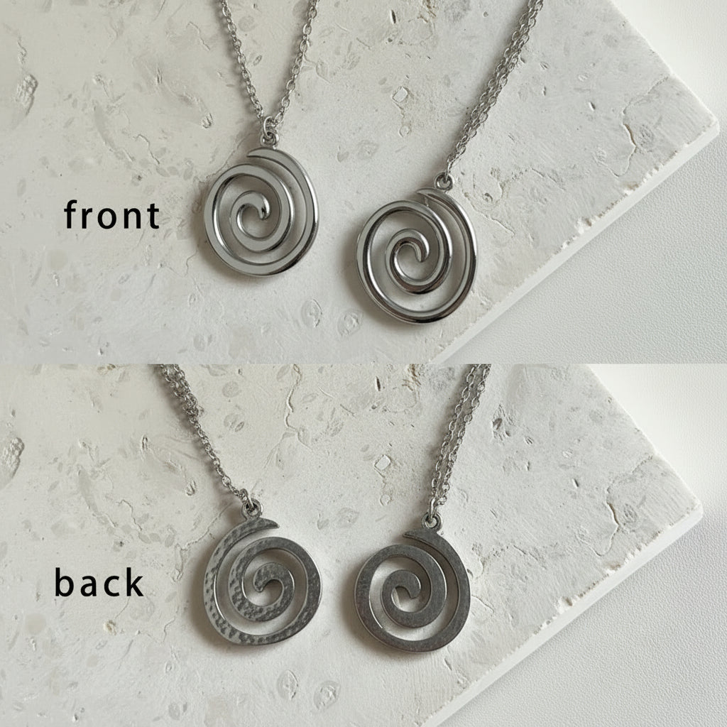 Two spiral necklaces, one silver and one gold, on a marble surface with labels for front and back views.