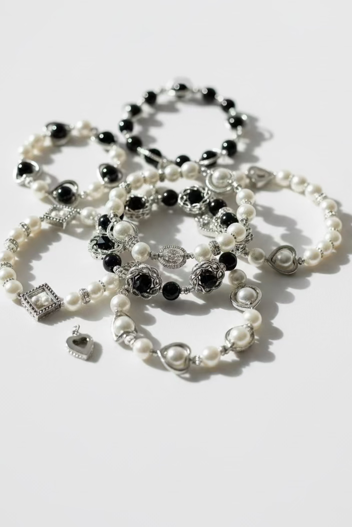 Bracelets with black and white pearls on a light gray background