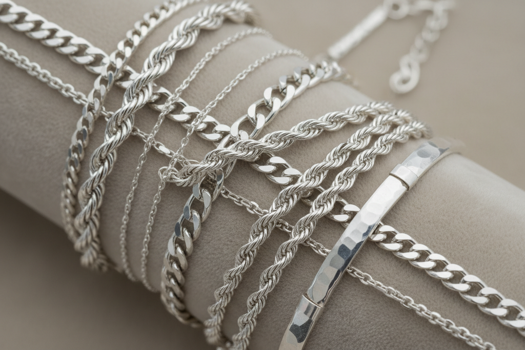Collection of silver chains on a neutral background