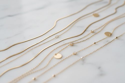 Gold bracelets with various on a marble surface