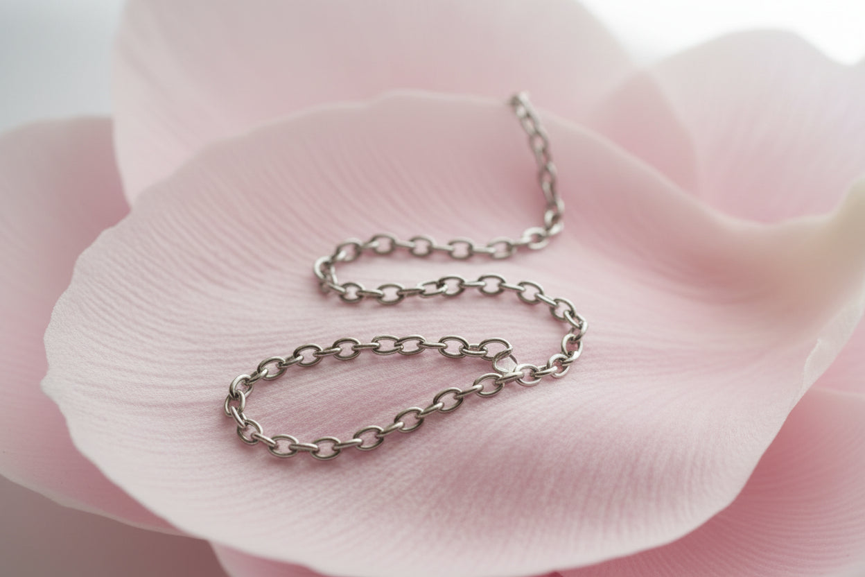 Silver stainless steel 3mm thick chain link on a large pale pink petal