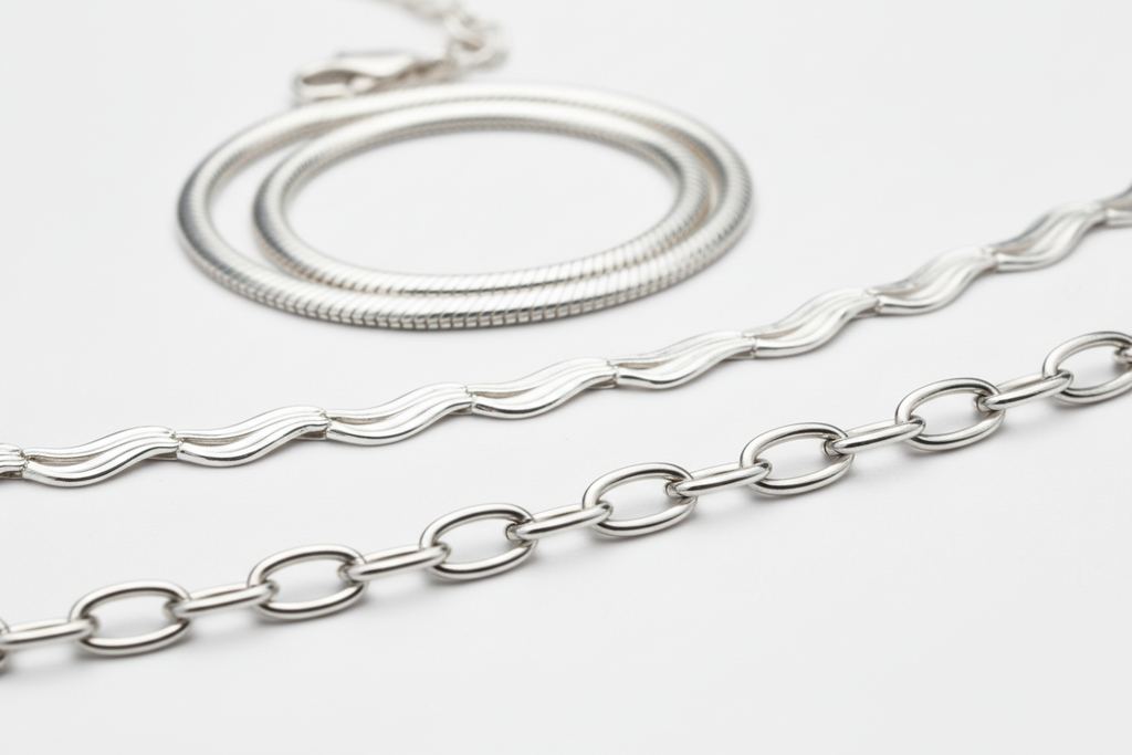 Two silver necklaces on a light gray background